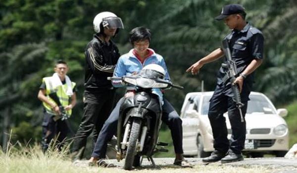 Anggota polis memeriksa dua remaja yang melalui Jalan Tanjung Labian, di Felda Sahabat dalam usaha untuk mengetatkan lagi kawalan pada hari kesepuluh Op Daulat